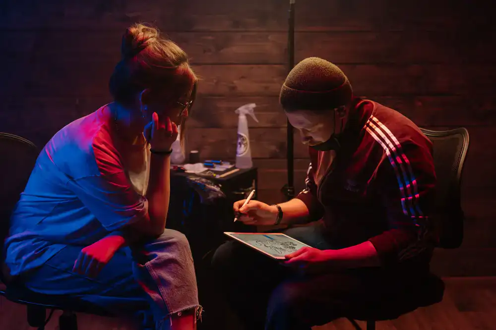 Game developer sketching concept art on a digital tablet in a dimly lit studio